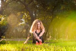 Happy woman sitting on sunny lawn