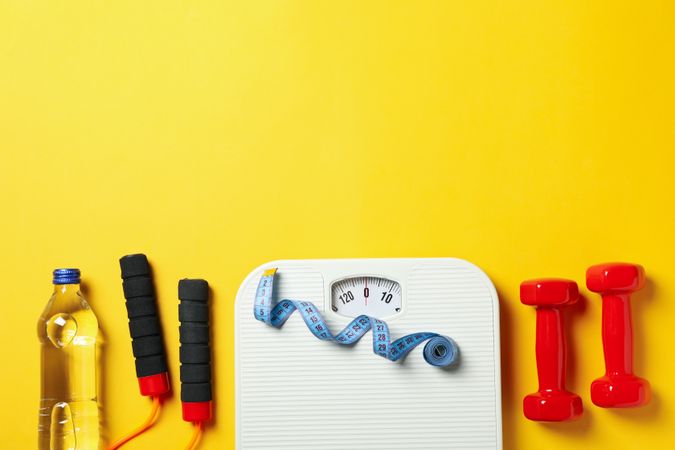 Weight loss or healthy lifestyle accessories on yellow background