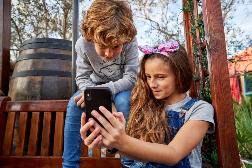 Children watching video in backyard