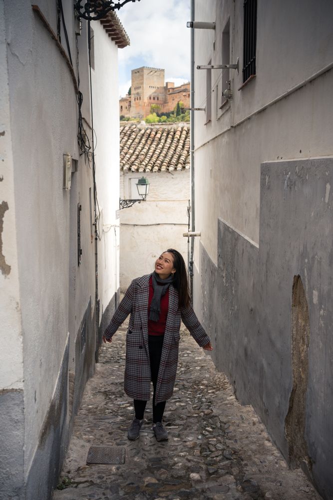 Joyful female tourist in casual wear amid city street
