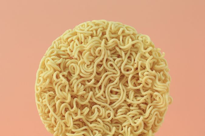 Circle of noodles on peach background