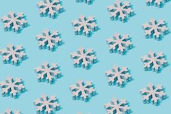 Pattern composition of light  snowflakes on pastel blue background