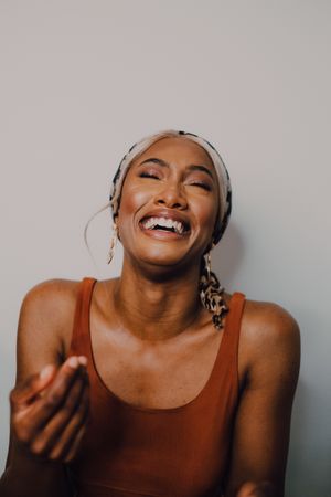 Black woman wearing headscarf and brown dress