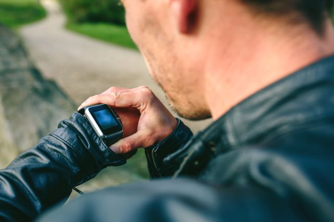 Unrecognizable young man looking at his smartwatch