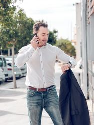 Punctual man checking time on wristwatch on street