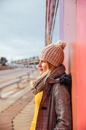 Blonde woman leaning on a colorful wall
