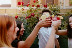 Group of cheerful friends clinking glasses at party