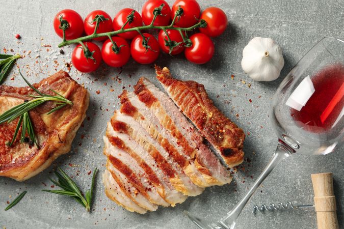 Composition with fried steaks, wine and vegetables. Grilled food