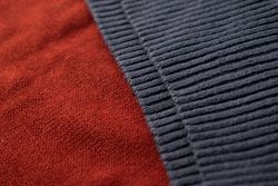 Close up dark grey knitted fabric background texture.
