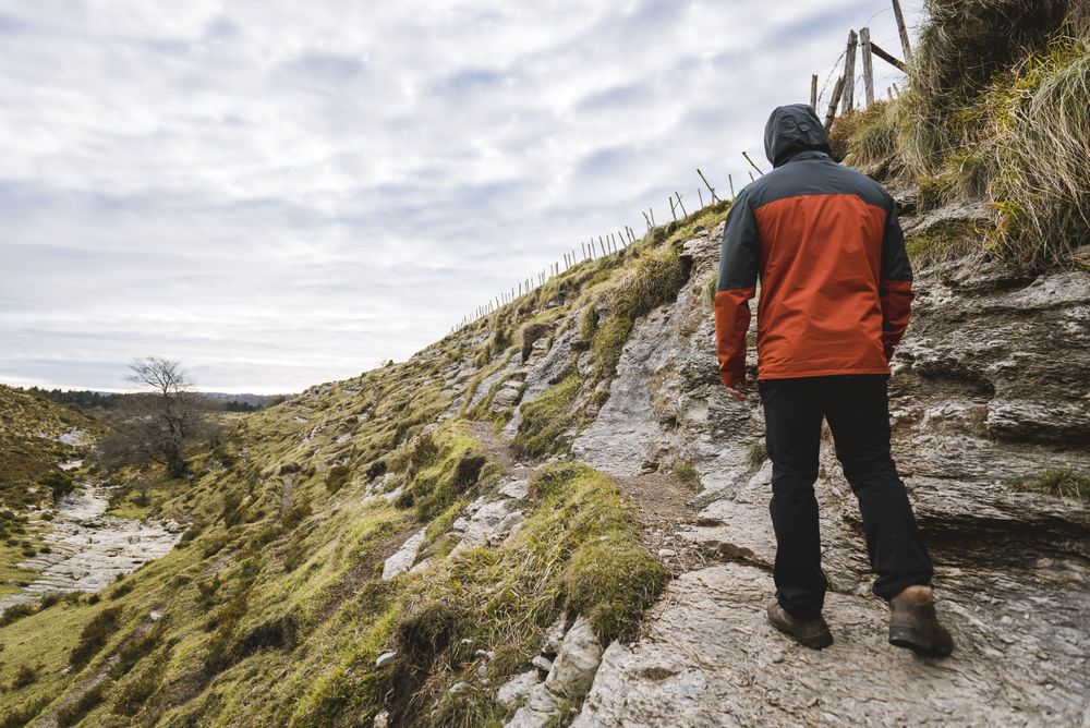 Man walking on hill near valley