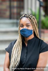 Close up portrait of doctor with blonde braids wearing mask and scrubs bE9Yob