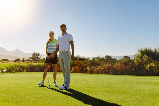 Sporty couple posing on a golf course