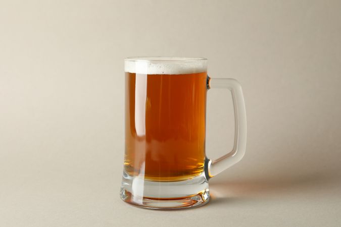 Glass of beer on gray background, space for text