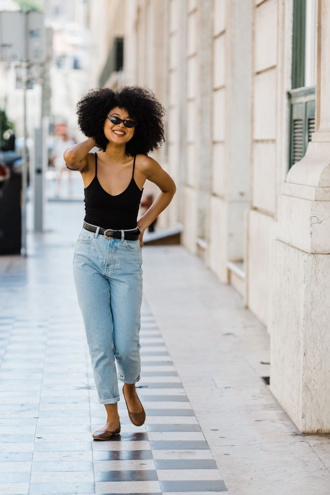 Cheerful Black female in dark sunglasses