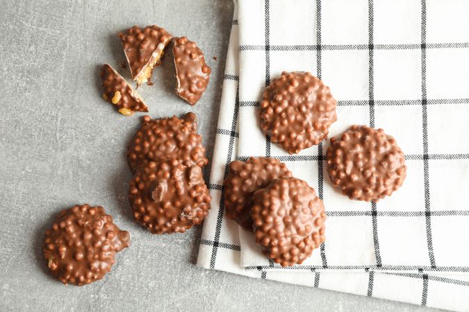 Chocolate cookies and kitchen towel on grey table, top view