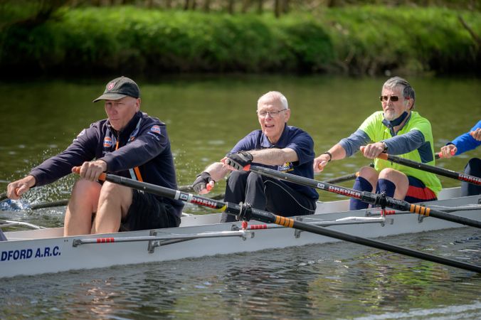 Mature men rowing in river