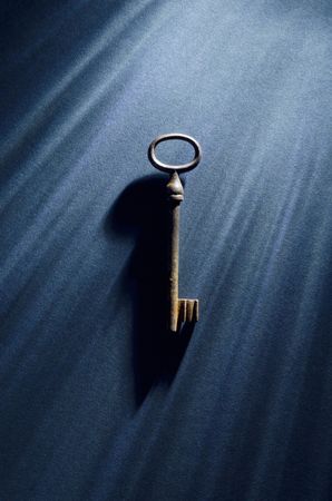 Vintage key over dark background with dramatic lighting