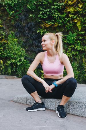 Woman in sportswear sitting outside