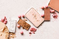 Powdered blush and eyeshadow on light pink background