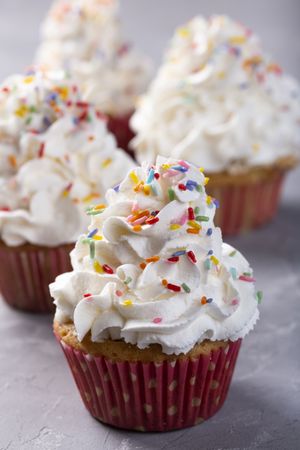 Tasty party cupcakes on the table. Cupcakes with whipped cream.