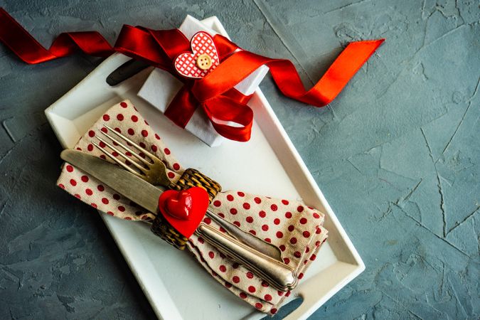 St. Valentine day table setting with dotted napkin wrapped silverware, copy space