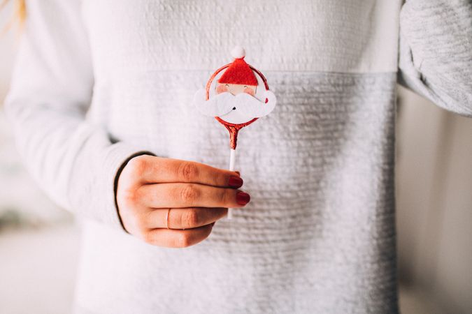 Woman holding a festive Santa Claus treat