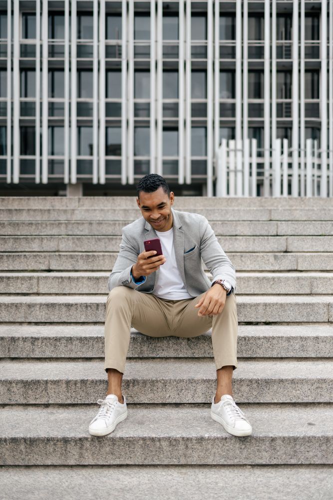 Man sitting on stairs using smartphone