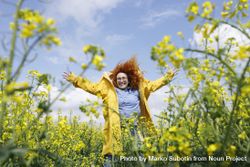 Joyful red haired woman smiling in a rapeseed field 0ye2R0