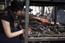 Woman wearing goggle holding metal tool
