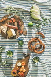 Summer picnic spread with pretzels, mojitos, meat and cheese board