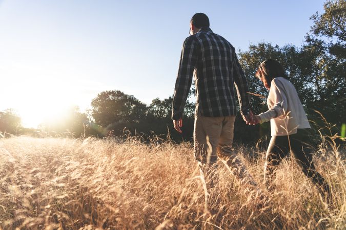 Loving couple walking in golden rural field