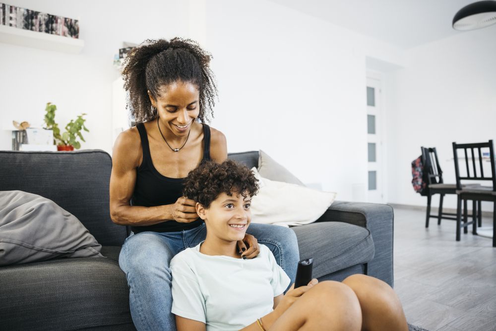 Mother and her daughter sitting on sofa