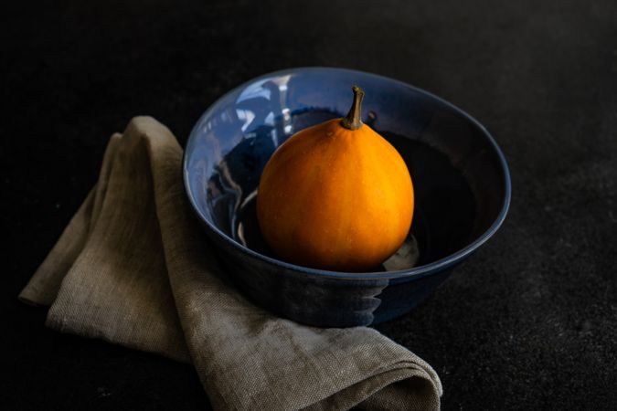 Single orange squash in blue bowl
