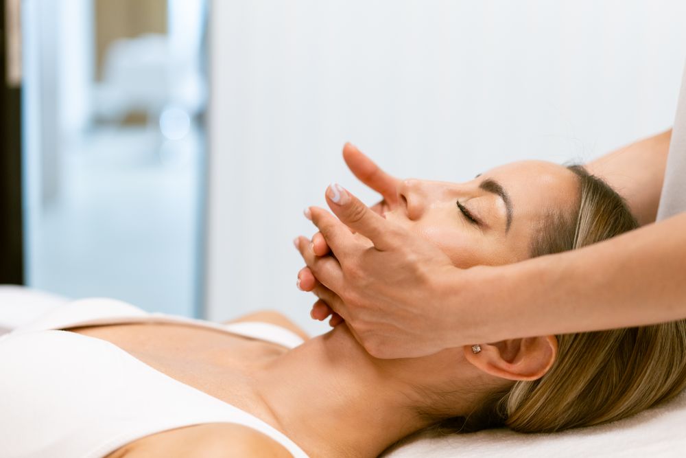 Side view of woman having relaxing face massage