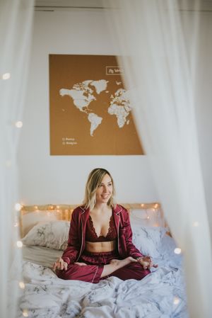 Young woman meditating on bed