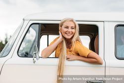 Woman leaning out of driver’s window of car with long blonde hair 5qoZob