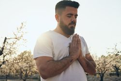 Bearded man meditating in spring garden