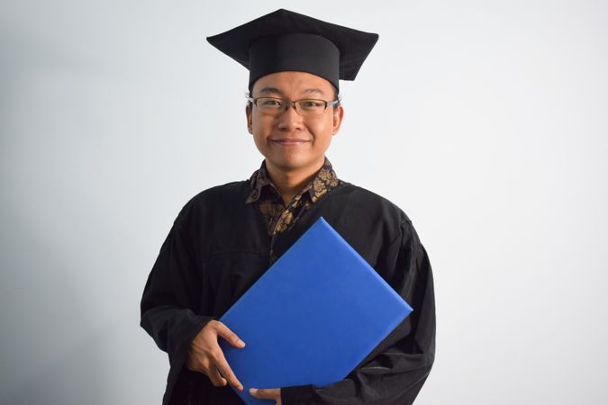 Man posing in graduate shoot holding a certificate
