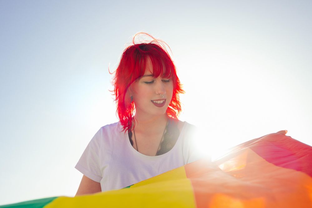 Young woman holding rainbow flag