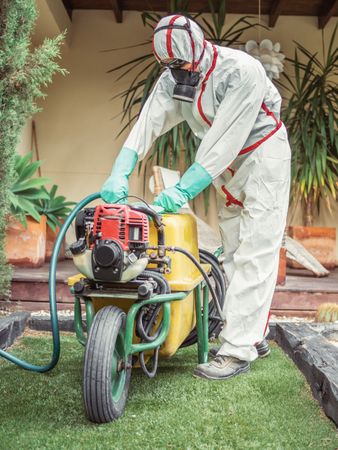 Fumigator pulling treatment hose from machine in yard