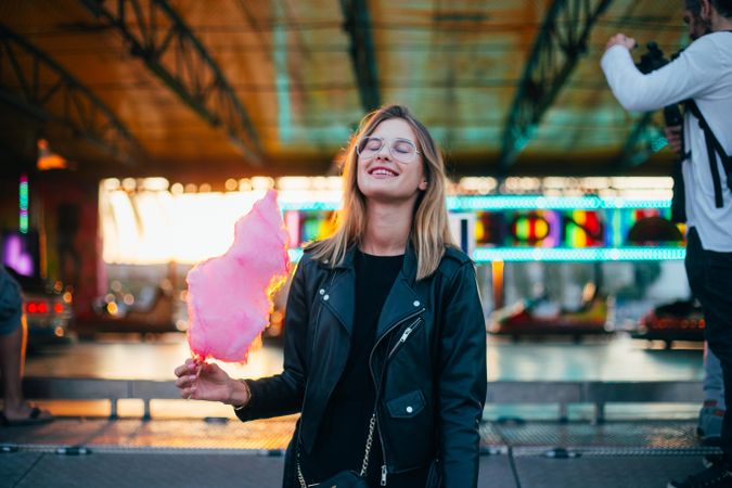 Trendy woman smiling in underpass with cotton candy