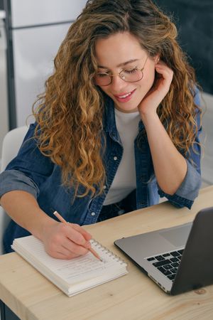 Smiling woman writing in notepad