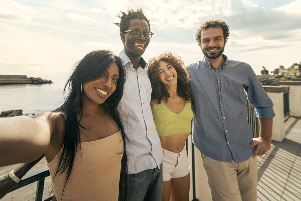 Group of diverse friends taking a selfie by the sea