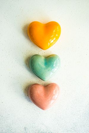 Three ceramic hearts on marble surface