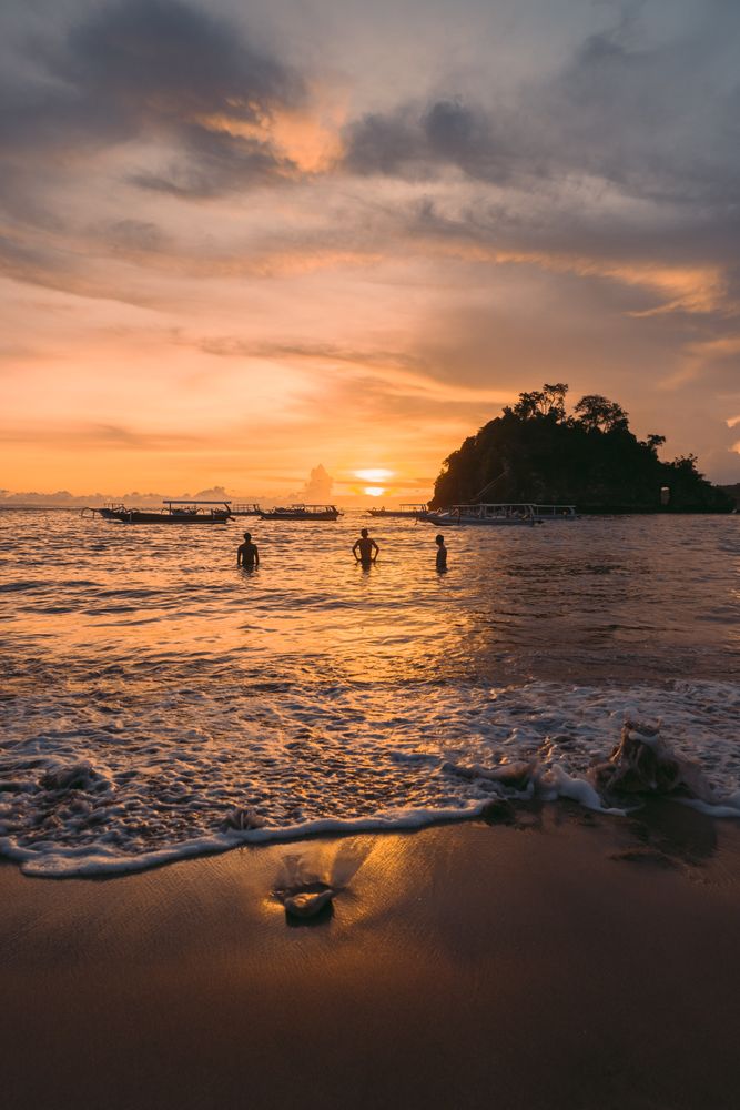 Silhouette of people in the sea during sunset