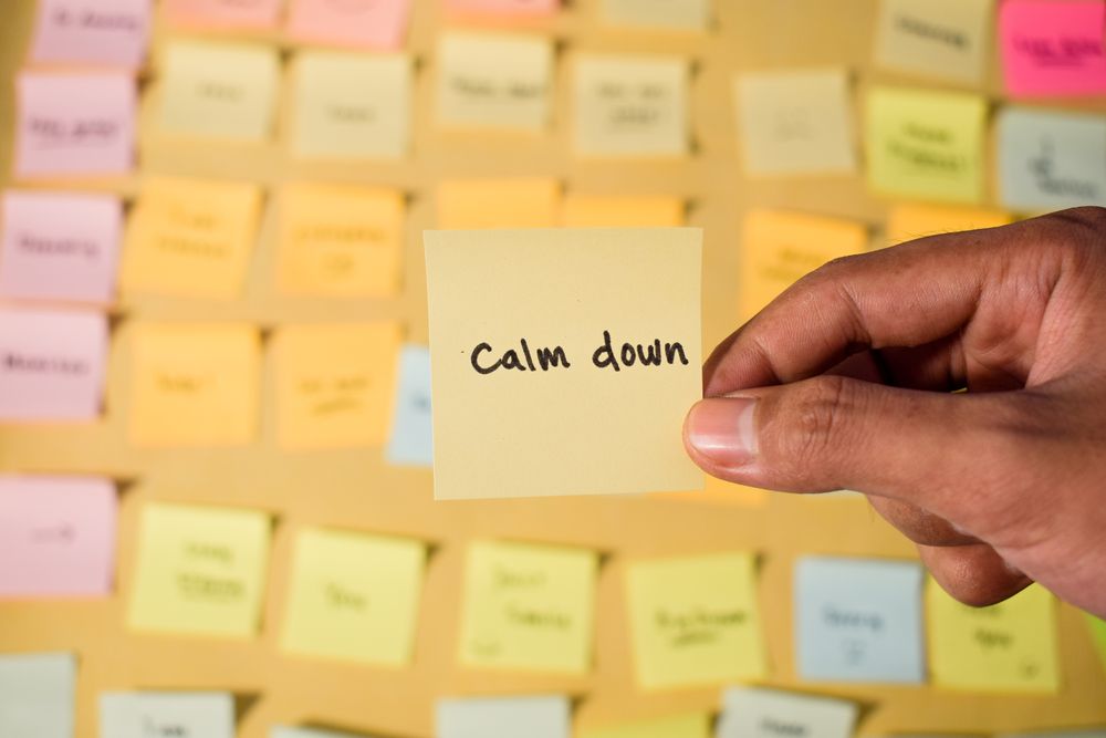 Hand hold sticky notes with words Calm Down