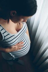 Pregnant woman looking her belly