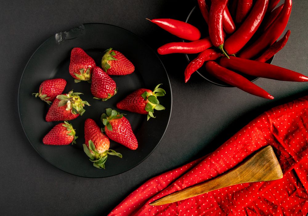 Cloth and branches near peppers and strawberries