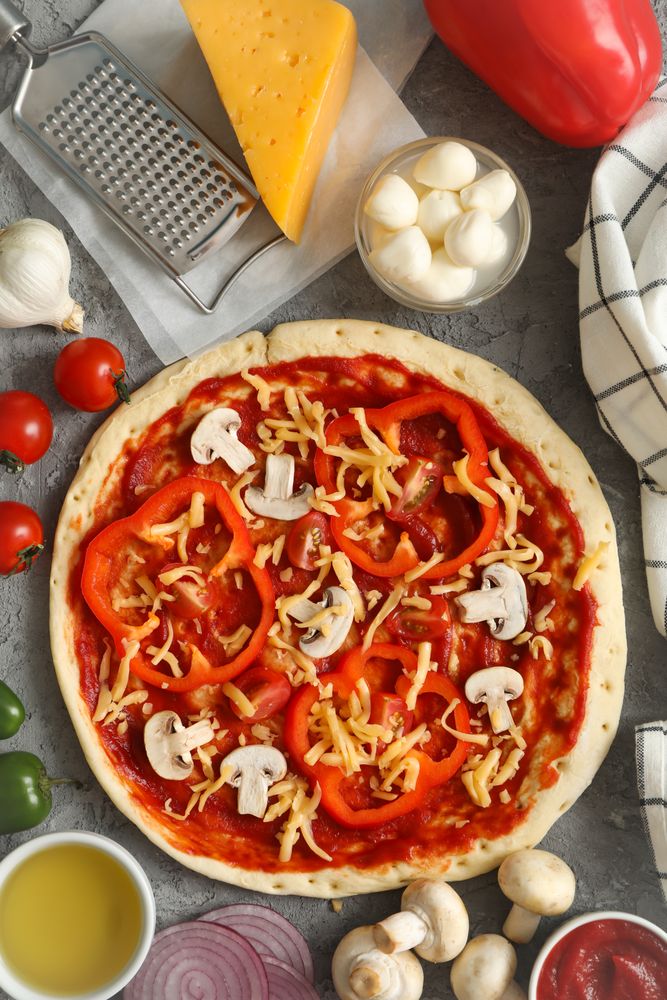 Concept for cooking pizza with ingredients on gray table