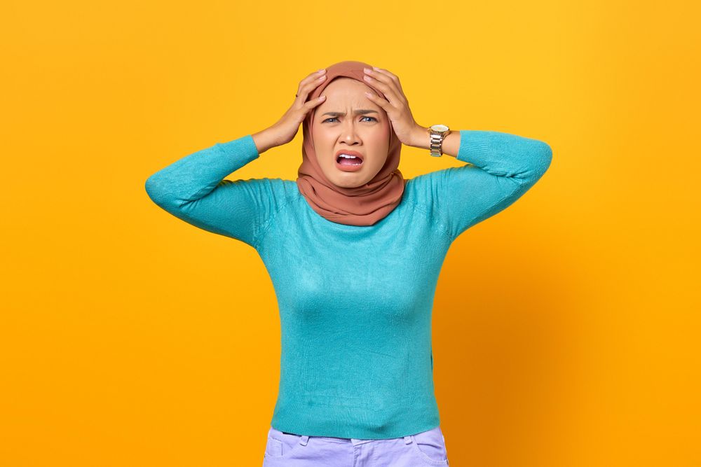 Disgusted Muslim woman with hands on her head